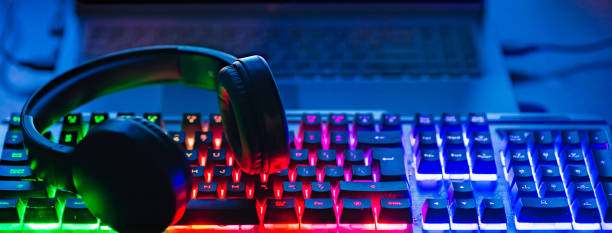 istock Pro gaming illuminated desk, headset, keyboard, computer neon lights. Cyber sport equipment laying on desktop, ready for online video gaming.Dark shot.Banner,advertisement. 2099352162