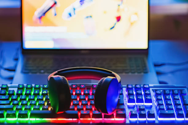 istock Gamer workspace concept.Gaming gear, keyboard, joystick, Headset illuminated background with RGB Color.Dark shot. 2099364011