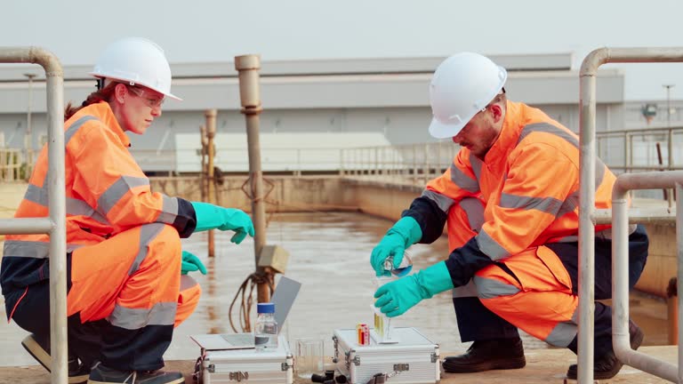 Two Water plant maintenance technicians work at wastewater treatment plants,Environmental engineers check the control system at the water treatment plant.