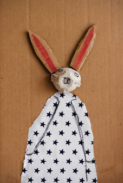 Easter rabbit made by a child from egg packaging, carton and a piece of cloth. Creative simple DIY Easter crafts. Eco friendly reuse recycle decoration for Easter,