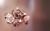 Solitaire Diamond Ring among diamonds on an orange satin gradient background