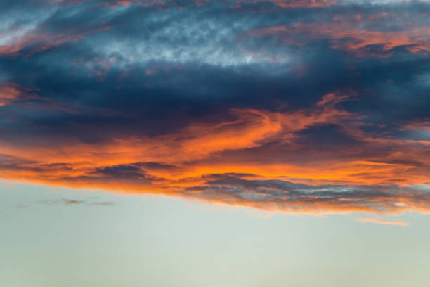 istock Sunrise or sunset with vivid orange clouds, ideal for warm-toned projects 2099400207