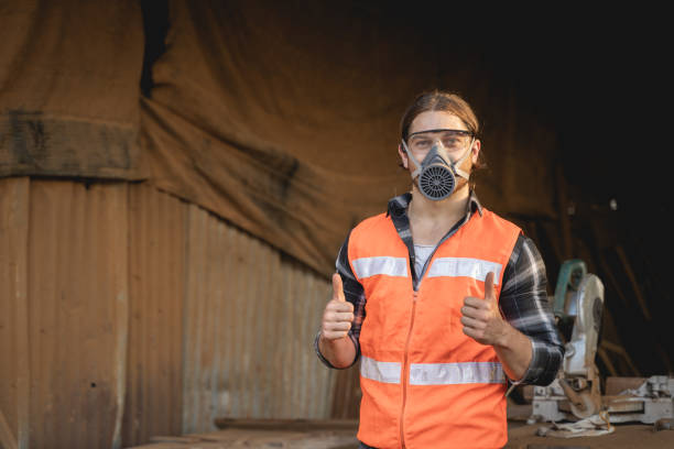 istock Young male carpenter working on design and cutting wood in the workshop, using a circular saw to cut a large board of wood on a wooden table in the workshop 2099413781