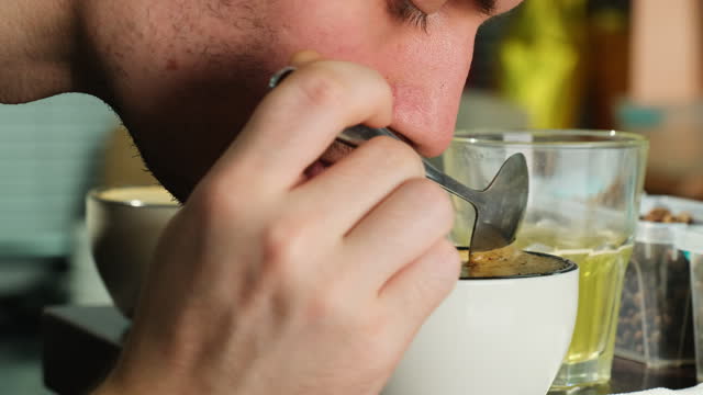 Man conducts ritual of smelling coffee to assess quality