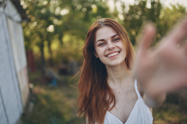 istock happy woman gesturing with hands outdoors in garden summer trees vacation 2099463775