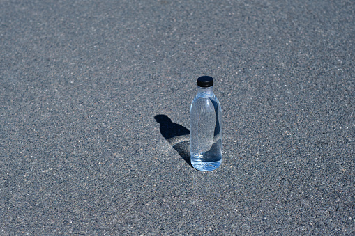 creative, minimalistic, colorful and funny front view of a bottle of water on a gray ground