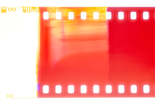 Macro image of a light-leak on a roll of photographic color negative film, on a white background.