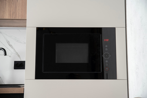 Black built-in microwave oven in kitchen furniture