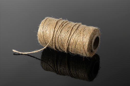 A skein of linen thread on a black background.