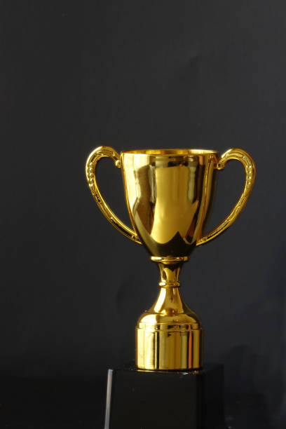 istock Gold plated trophy on a stand with a black background 2099559034