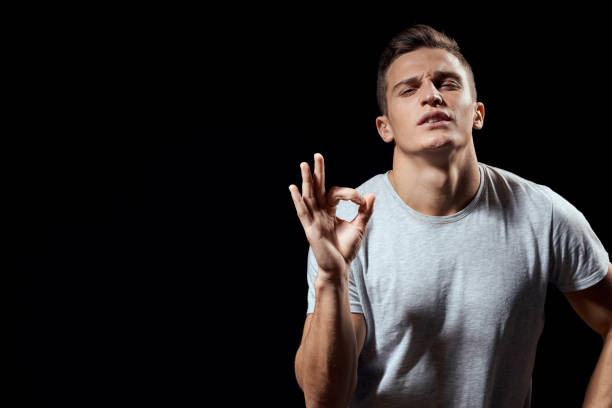 istock Cheerful man white t-shirt gesture with hands black background sport 2099568905