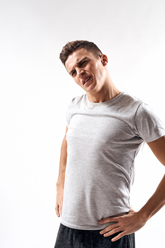 sporty man in white t-shirt on a light background gesturing with his hands cropped view Copy Space. High quality photo