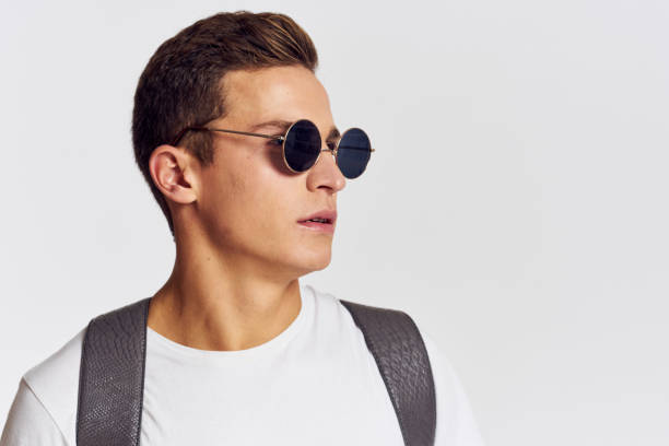 istock man in sunglasses with a backpack on his back and in a white t-shirt on a light background cropped view of emotion 2099606413