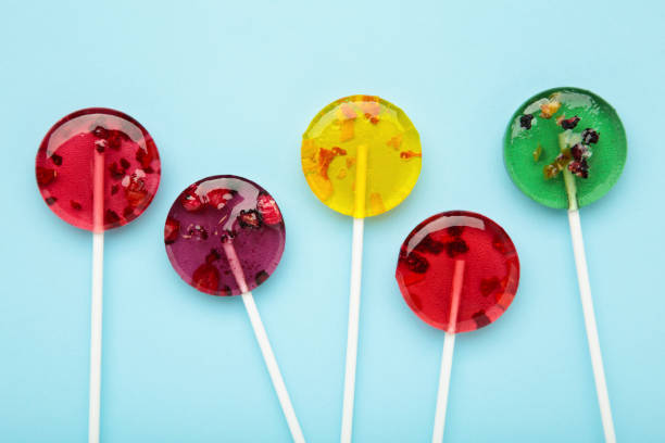 istock Colorful sweet lollipops with berries on blue background. 2099648294