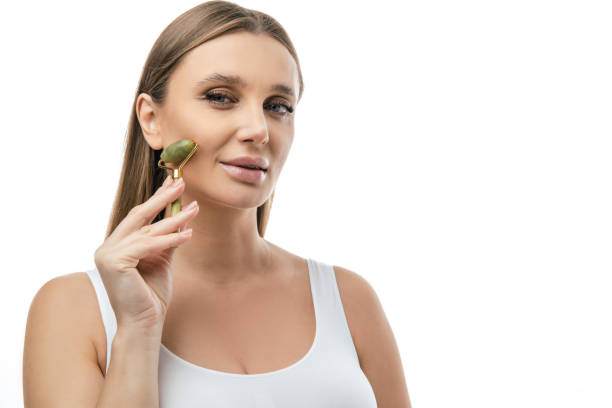 istock Blonde woman making face massage with a roller 2099648323