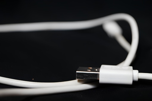 A white usb cable with a black background. High quality photo