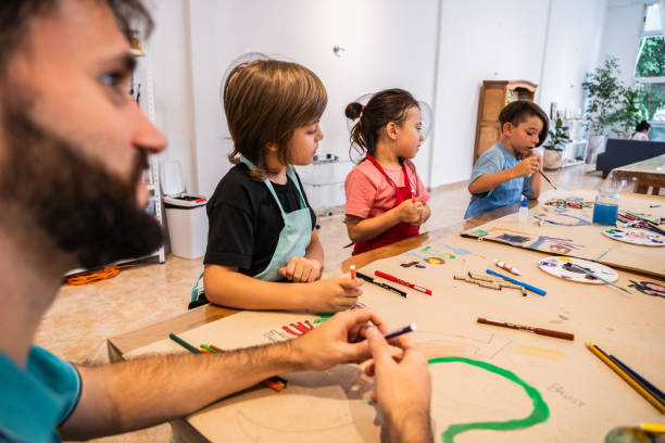 istock Kids painting on cardboard poster during paint class at workshop 2099674566