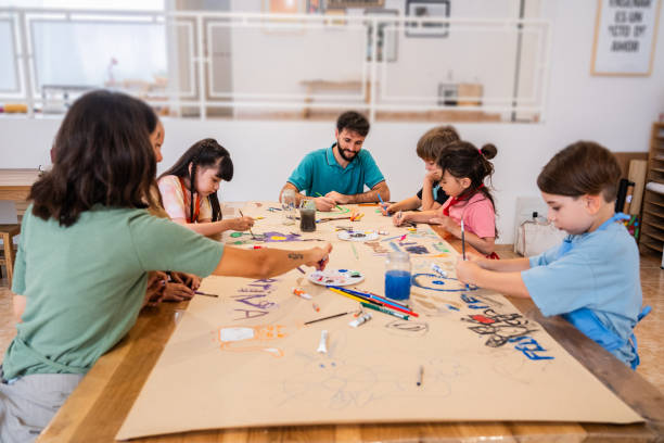 istock Kids painting on cardboard poster during paint class at workshop 2099675088