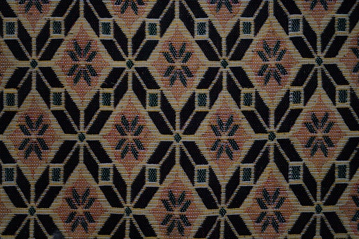 A patterned carpet with a black and brown color scheme. High quality photo