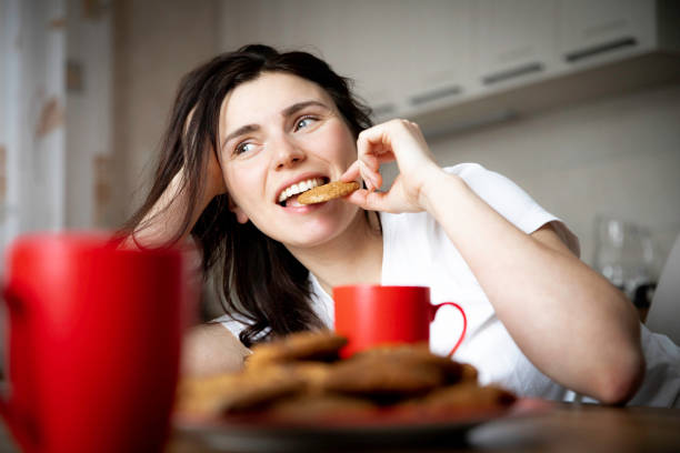 istock Young beautiful brunette is having breakfast in the home kitchen. 2099684737