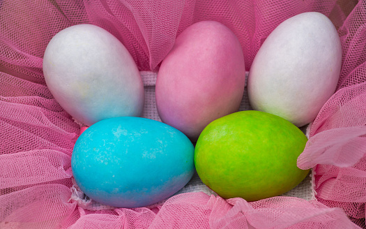 Easter. Close up of colored eggs on a beautiful pink veil.