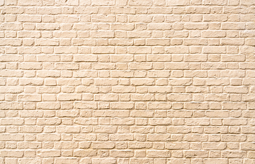 A large area of brick wall, painted light beige.