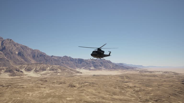 A helicopter flying over a desert landscape with a mountain in the background