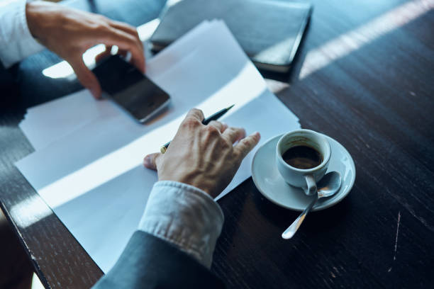 Business man in a cafe documents a cup of coffee on the table official work. High quality photo
