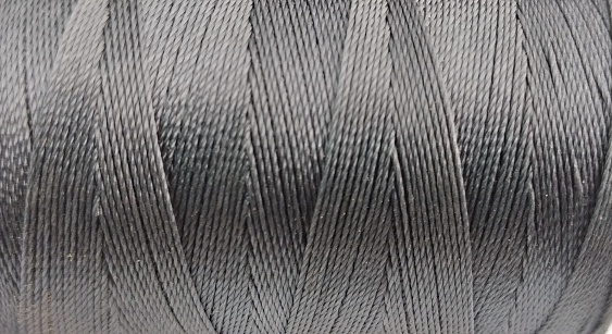 close up of a spool of thread on a white background.