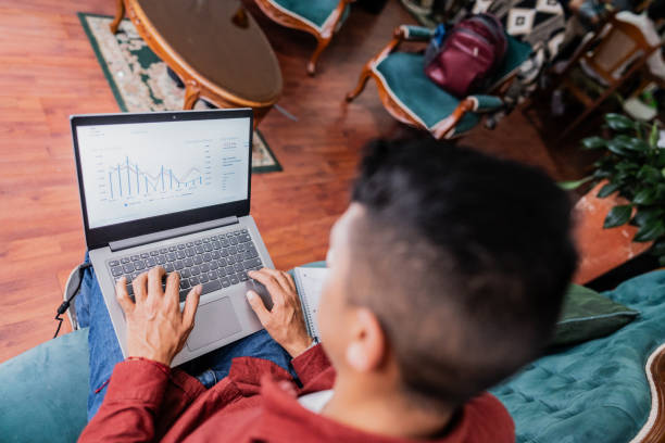istock Mid adult man using laptop at home 2099706302