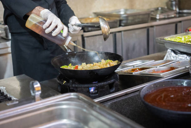 istock Chef pouring sauce over pasta 2099707911