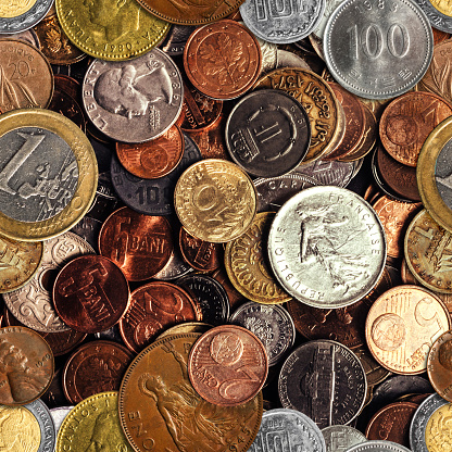 Seamless texture photo of old and modern world coins pile pattern.