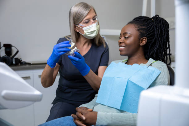 istock Female dentist showing dentures to her patient 2099720334