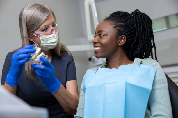 istock Woman dentist showing dentures dental prosthesis 2099720344