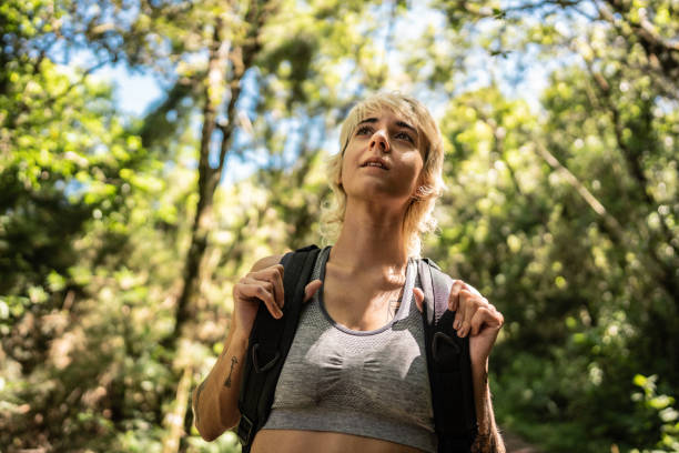 istock Young woman walking and looking around hiking on forest 2099741713