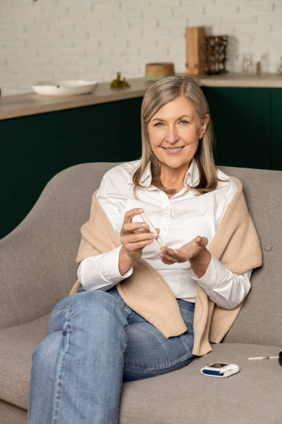 istock Smiling good-looking woman with blood sugar testing stick 2099745494