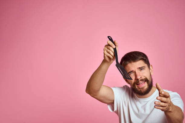 istock Man with spatula in hands kitchen accessories model emotions pink background cropped view Copy Space 2099755648