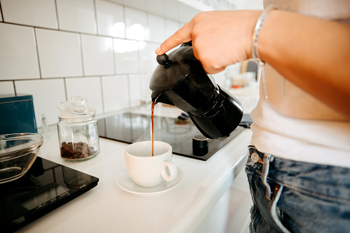 Woman prepares morning coffee in domestic kitchen