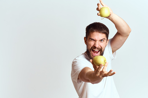 A man in a white t-shirt vitamins fruit diet vegetarian. High quality photo