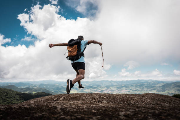istock Rear view of a young man jumping on trail on a mountain 2099771396