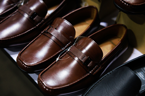 Leather shoes were lined up on the store shelves. Men elegant shoes in a man clothing boutique. Shoes trade show.