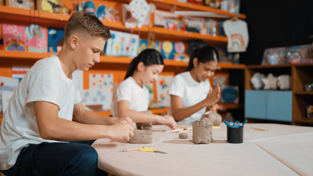 istock Group of happy smart diverse student working with clay at workshop. Edification. 2099788454