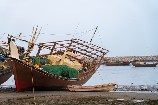 Close up of a traditional wooden fishing Dhow boats resting on the coast at Ras Al Jinz, Oman