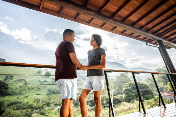 istock Young homosexual couple talking on balcony farm inn 2099821852