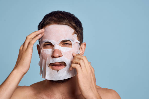 istock man in cleansing mask on blue background gesturing with hands naked torso cropped view 2099822186