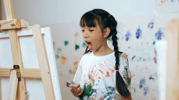 istock Young student painted or draw canvas at stained wall in art lesson. Erudition. 2099839985