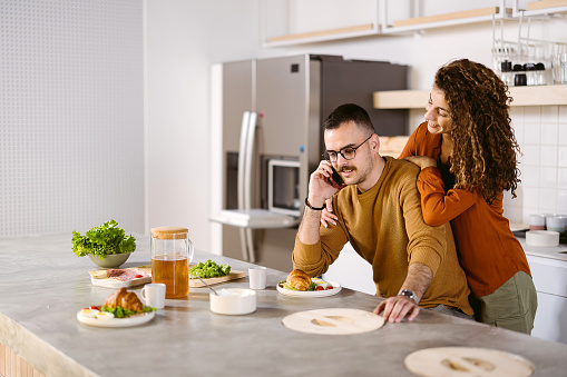Young couple is having breakfast in the kitchen of their home.