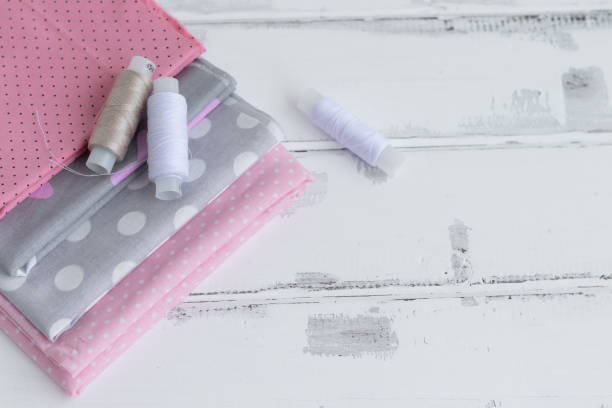 istock a stack of cotton fabrics, threads on a white wooden background.Copy space 2099853020