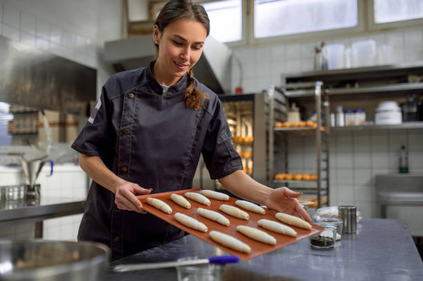 istock Woman baker baking croissant in bakehouse 2099861224