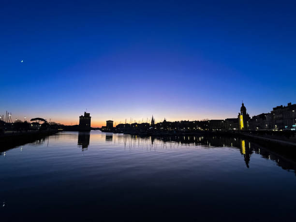 istock La Rochelle: skyline and old harbor with sunset and moon 2099863389